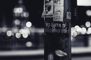 Lightpost in a city street with sign big data is watching you