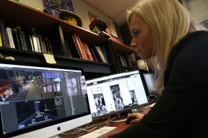 Woman working on a computer with multiple monitors