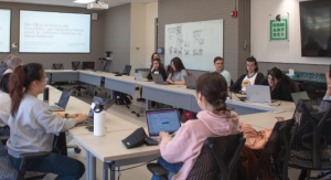 Picture of students sitting around a table in a modern conference room